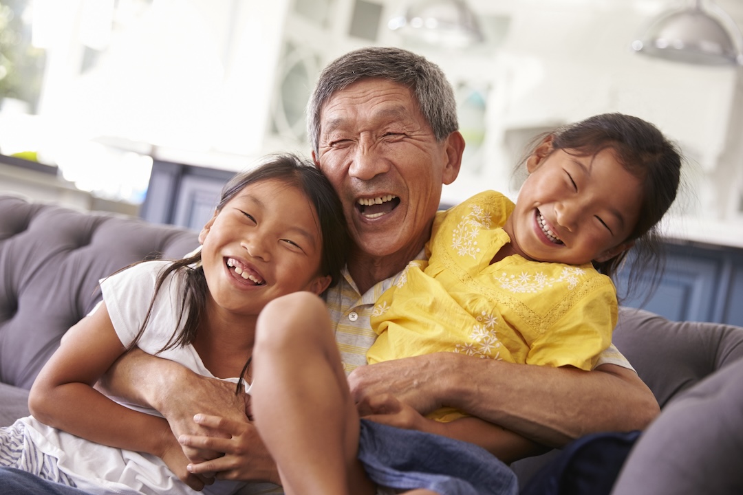 Older man And younger girls Relaxing On Sofa At Home